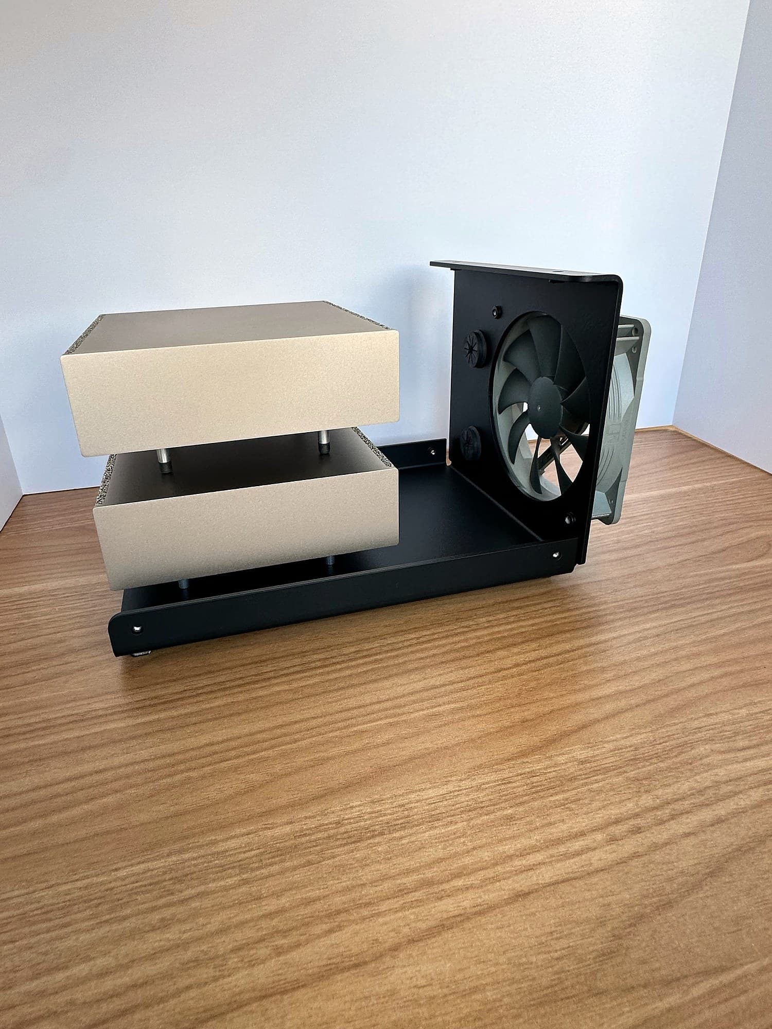 Two NVIDIA DGX Spark units stacked on the Stackcooler TP2 black steel base with the clear cover removed, next to the rear fan wall.