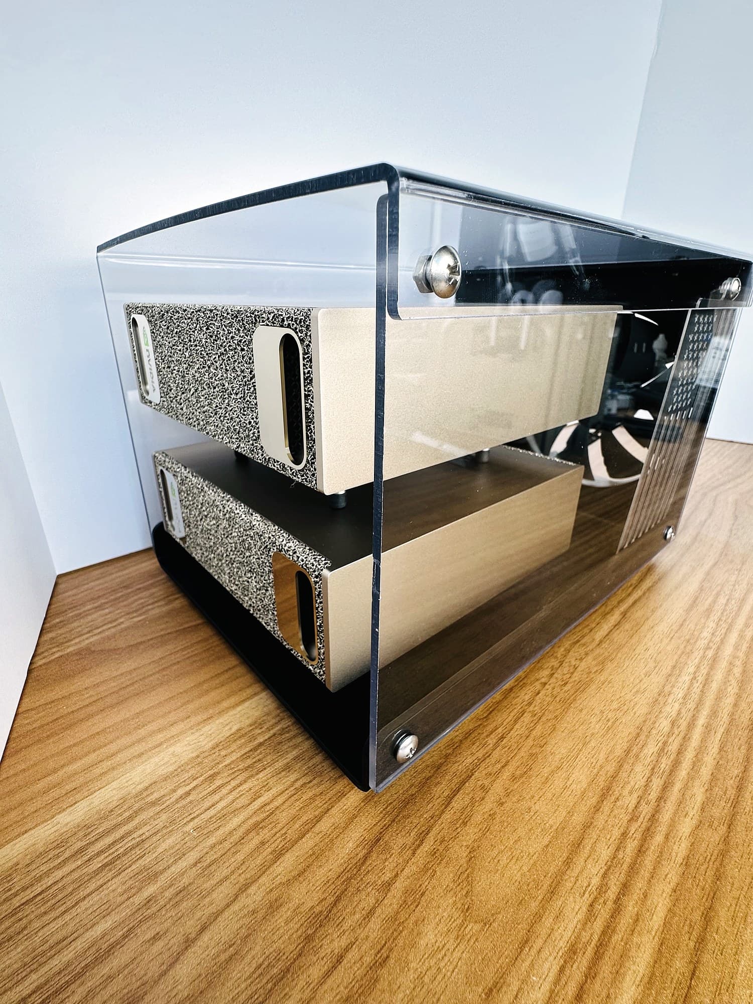 Stackcooler TP2 with the bent clear acrylic cover installed, seen from a three-quarter side angle with two stacked DGX Sparks inside.