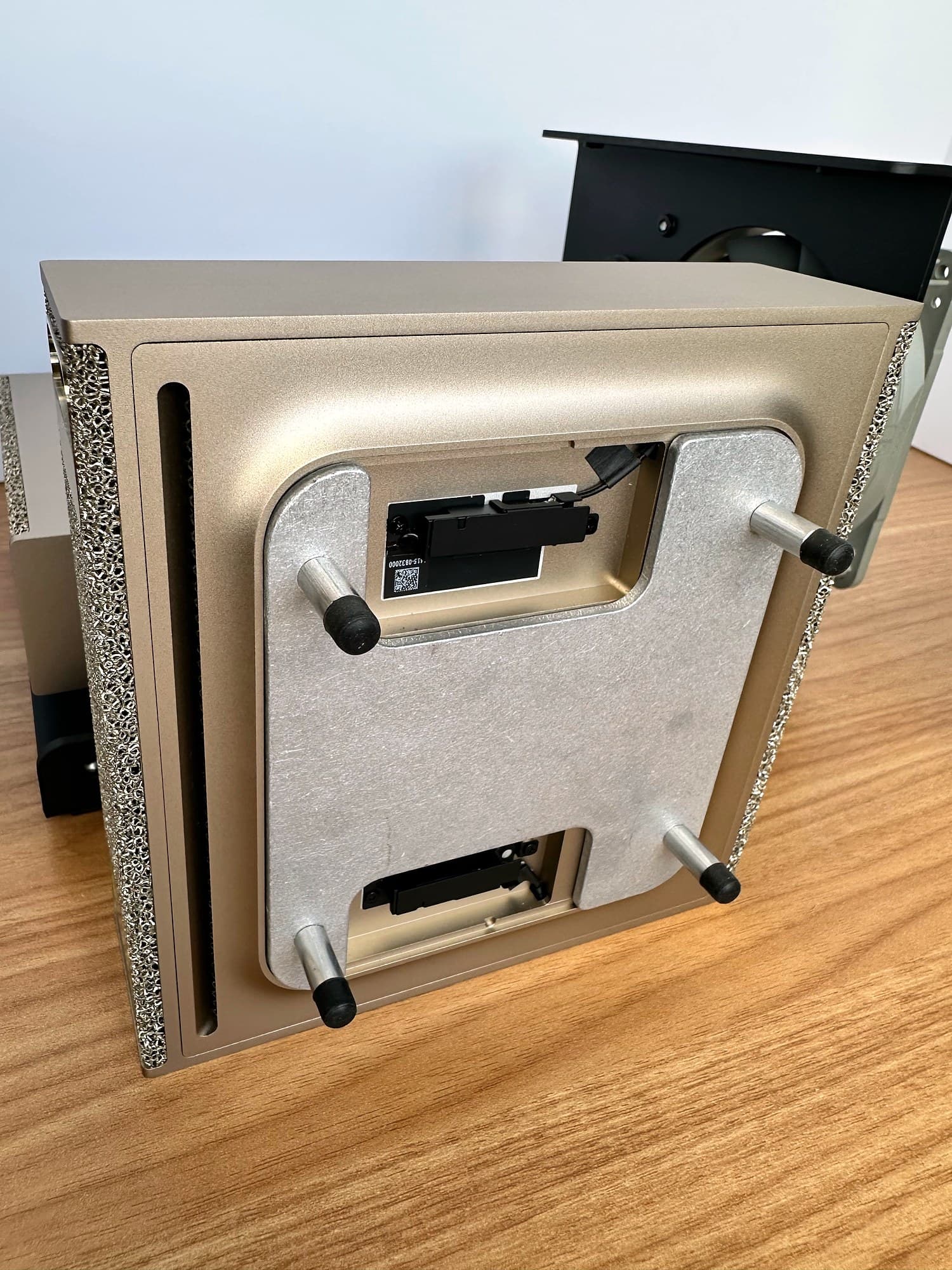 Aluminum H-bracket spacer attached to the underside of the upper DGX Spark, with its four standoffs pointing up.
